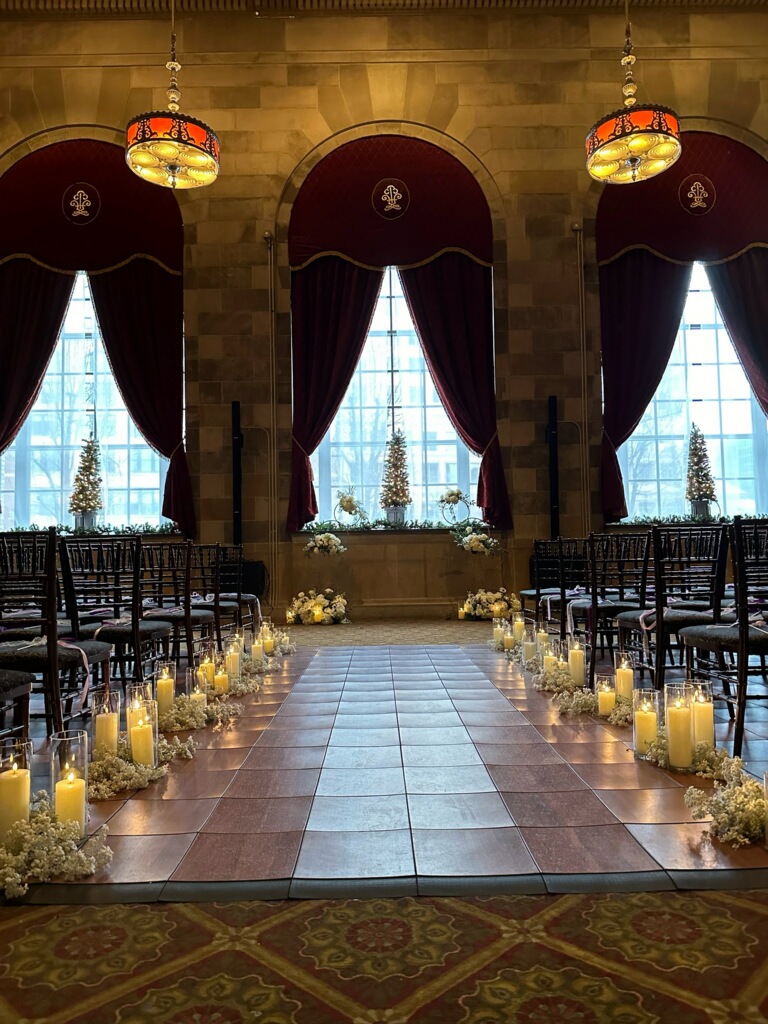 Candlelit ceremony aisle in a grand ballroom before guests arrive
